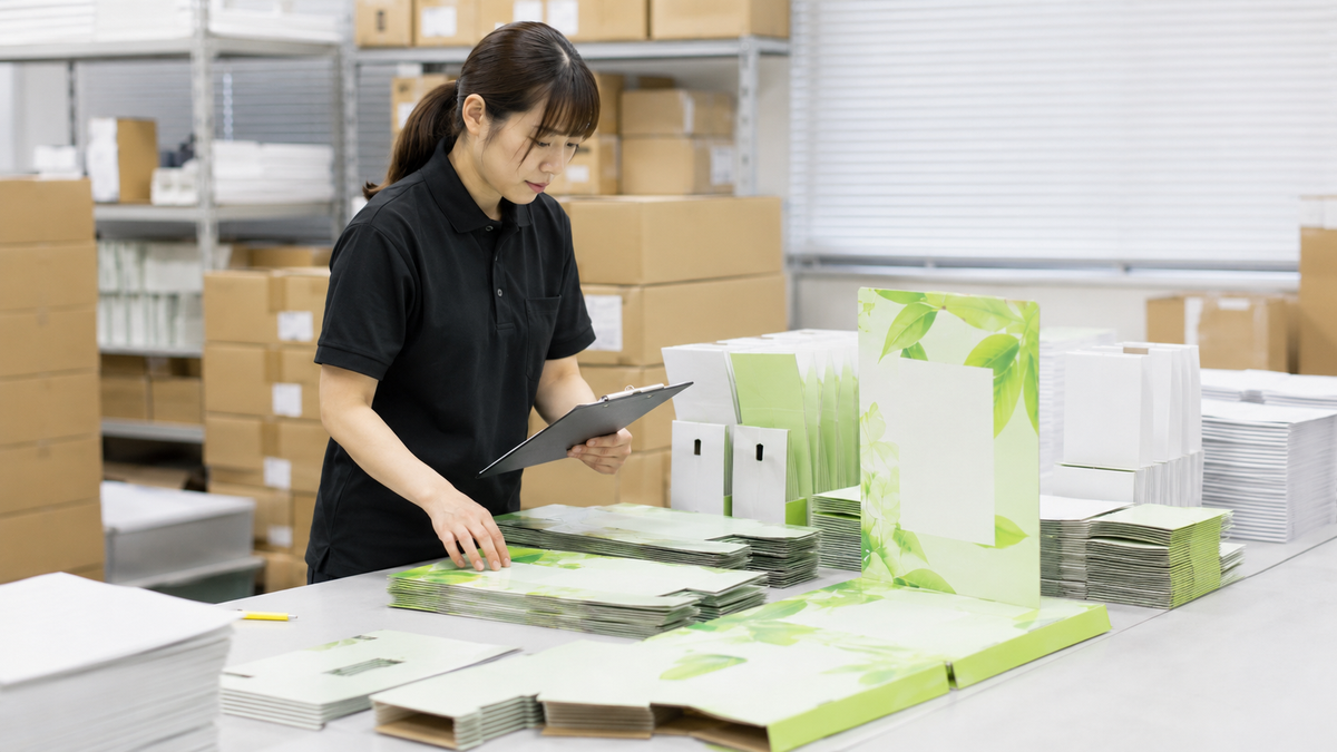 販促物の品質と数量を確認する作業スタッフ